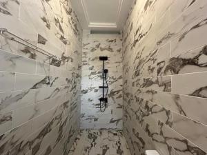 a bathroom with marble walls and a shower at OREMA Residence in Cotonou