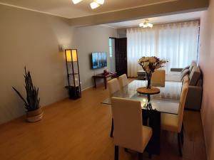 a dining room and living room with a table and chairs at Apartamento Limas Airport in Lima
