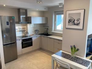 a kitchen with a refrigerator and a table in it at Apartament 4 You in Swarzędz