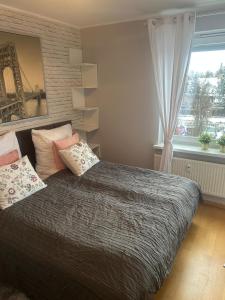 a bedroom with a bed with pillows and a window at Apartament 4 You in Swarzędz