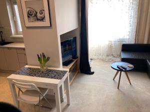 a living room with a table and a tv at Apartament 4 You in Swarzędz
