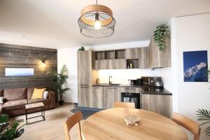 een woonkamer met een tafel en een keuken bij Le Refuge Tropical Taine in Annecy