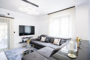 a living room with a couch and a tv at Sunrise Palace in Sarud