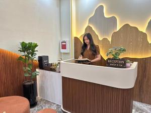 a woman standing at a reception desk in a room at Xing Ocean Vũng Tàu in Vung Tau