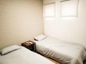 a small room with two beds and a window at shinka 新しいお家 in Nagano
