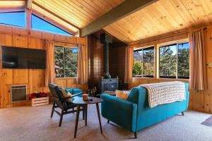 a living room with a blue couch and a table at RACC00N Rock Charming Hot Tub Cabin in Pine Cove