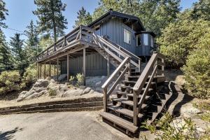 a tiny house with stairs leading up to it at RACC00N Rock Charming Hot Tub Cabin in Pine Cove
