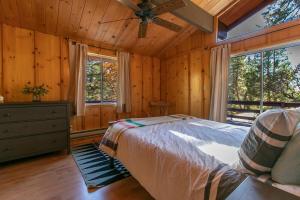 a bedroom with a bed and a ceiling fan at RACC00N Rock Charming Hot Tub Cabin in Pine Cove +26 photos