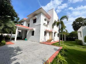 una gran casa blanca con entrada para coches en Pearl House Villa Panayur ECR Beach, Chennai, en Chennai
