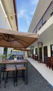 a patio with tables and chairs and a large umbrella at JMorino Pension House in Puerto Princesa City