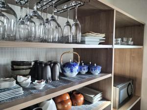 a shelf filled with lots of glass vases and plates at shinka 新しいお家ーWestー in Nagano