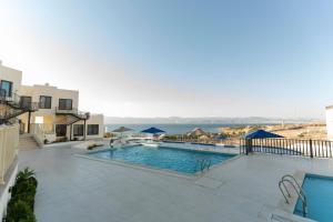 a swimming pool with a view of the ocean at Diamond Palm Hotel & Resort in Al Burj