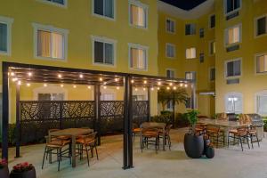 a patio with tables and chairs in front of a building at Homewood Suites by Hilton Bonita Springs, FL in Bonita Springs