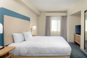 a hotel room with a bed and a television at Homewood Suites by Hilton Bonita Springs, FL in Bonita Springs