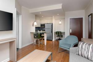 a living room with a couch and a table and a kitchen at Homewood Suites by Hilton Bonita Springs, FL in Bonita Springs