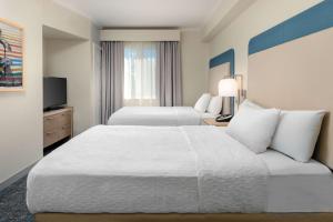 a hotel room with two beds and a television at Homewood Suites by Hilton Bonita Springs, FL in Bonita Springs