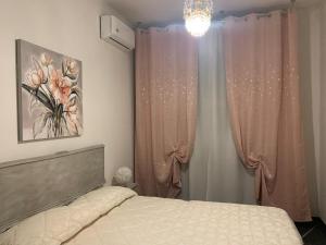 Un dormitorio con una cama con cortinas rosas y una lámpara de araña. en MAISON IVA & GIO' OLD STYLE, en Génova