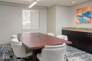 a conference room with a wooden table and white chairs at Homewood Suites by Hilton Bonita Springs, FL in Bonita Springs