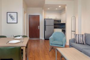 a living room with a dining table and a kitchen at Homewood Suites by Hilton Bonita Springs, FL in Bonita Springs