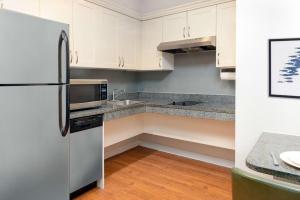 a kitchen with white cabinets and a refrigerator at Homewood Suites by Hilton Bonita Springs, FL in Bonita Springs