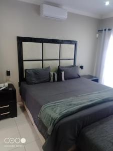 a bedroom with a large bed in a room at Reflections at 21 in East London +14 photos
