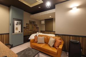 a living room with a couch in front of a bed at AND hotel in Fukushima