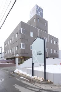 a building with a sign in front of it at AND hotel in Fukushima