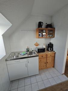 a small kitchen with a sink and a stove at Watt'n Wunder in Cuxhaven +8 photos