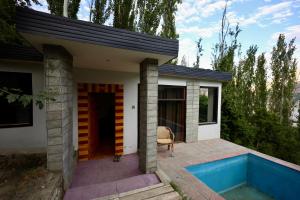 a small house with a blue swimming pool in front of it at Sanctuary Resort Hunza in Hunza Valley