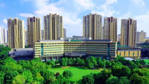 a large building in front of a city with tall buildings at Holiday Inn Changzhou Wujin by IHG in Changzhou