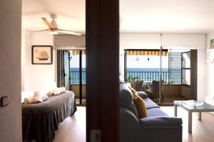 a living room with a couch and a view of the ocean at Apartaments Primera Linea Torre Valentina in Sant Antoni de Calonge