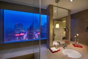 a bathroom with a sink and a window with a city skyline at Radisson Collection Hyland Shanghai in Shanghai
