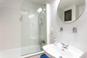 a white bathroom with a sink and a shower at Apartaments Primera Linea Torre Valentina in Sant Antoni de Calonge +64 photos