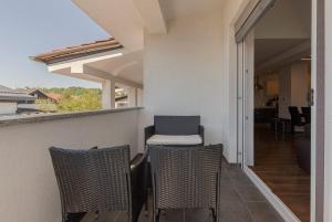 d'un balcon avec trois chaises et une chaise. dans l'établissement Frida's Place Ljubljana, à Ljubljana