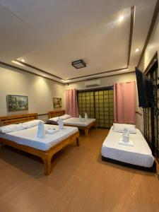 Una habitación con dos camas y un televisor de pantalla plana. en P3k suites barkada family room, en Manila