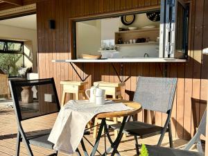 Un patio con mesa y sillas y una cocina. en Nook Living, en Riebeek-Kasteel