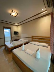 Un dormitorio con dos camas y un televisor. en P3k suites barkada family room, en Manila 8 fotos más