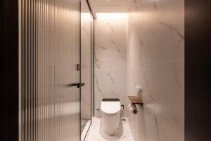 a bathroom with a white toilet and marble walls at Super 8 Hotel Beijing Sanlitun Taikoo Li Branch in Beijing
