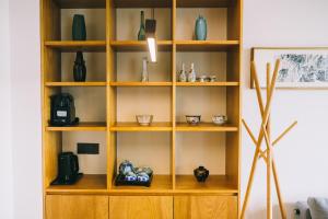 a wooden book shelf with vases on it at Miss Gu LAKE VILLA in Suzhou