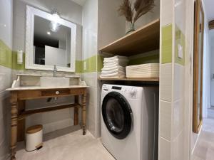 a bathroom with a washing machine and a sink at Loft de Babolène in Villefranche-de-Rouergue