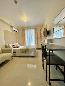 a bedroom with a bed and a table in a room at Affordable Staycation near Airport and beach in Suba