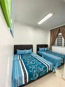 two beds sitting next to each other in a room at Wanie CH Homestay 1 Brinchang Cameron Highlands in Brinchang +1 photo