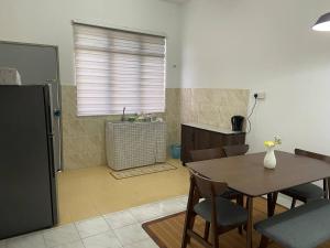a kitchen and dining room with a table and chairs at Homestay Idaman, Olak Lempit at Banting in Banting