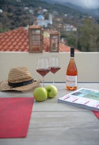 a table with two glasses of wine and a hat at Seagulls' House in Evdilos +29 photos