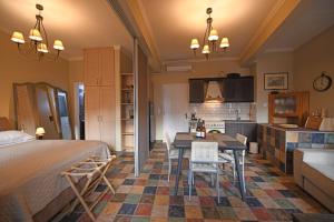 a bedroom with a bed and a table and a kitchen at Seagulls' House in Evdilos