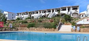 a swimming pool in front of a large building at Costa Arenal 81 in Arenal d'en Castell