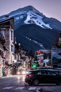 a car driving down a city street with a snow covered mountain at Ski Holiday accommodation in Bansko