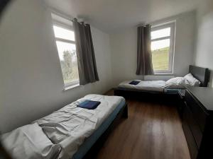 two beds in a room with two windows at Monteurwohnungen in Gera in Gera
