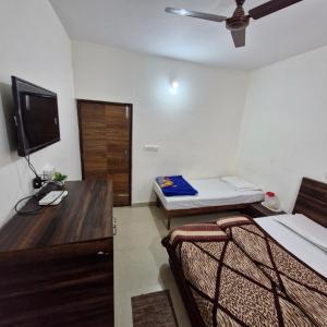 a room with two beds and a desk with a television at Saatvik Homestay with Free Pickup & Drop for Vaishno Devi Yatra in Katra +57 photos