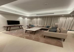 a living room with a couch and a tv at Bespoke Holiday Homes - Seaside Luxury 2BR in Address Residence, Fujairah in Fujairah